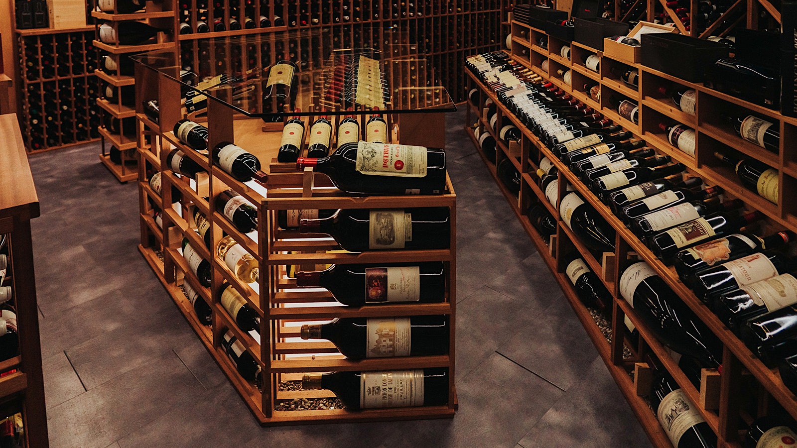 Bordeaux magnums and other bottles on wood racks in the cellar of Le Coureur des Bois